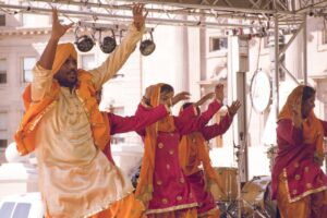 Colorful traditional Punjabi dance performance with vibrant costumes on an outdoor stage.