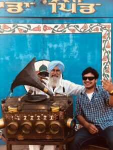 Colorful Indian cultural scene with gramophone and smiling people celebrating music.