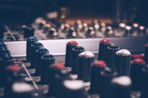 Close-up of audio mixer knobs in a dimly lit studio. Perfect for music and technology themes.